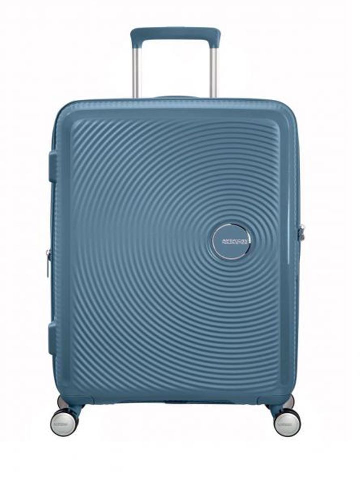 Maleta grande Soundbox American Tourister en color azul claro, vista frontal, carcasa rígida, ruedas 360° y diseño resistente